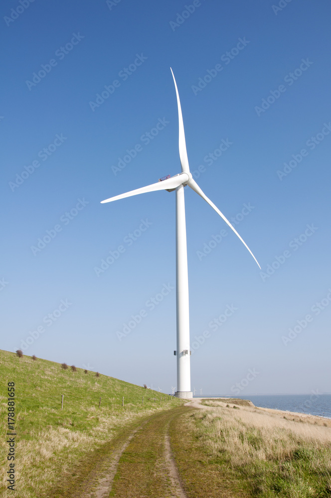 Wind turbine with a path to blue sky and ocean