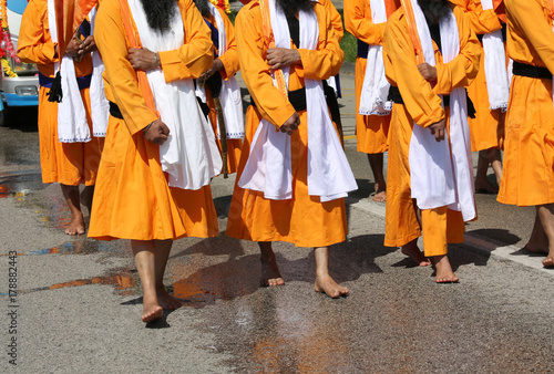 group of barefooted people with orange dresses during the religi