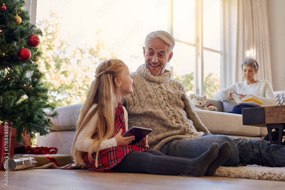 Obraz premium Senior man and granddaughter with digital tablet at home