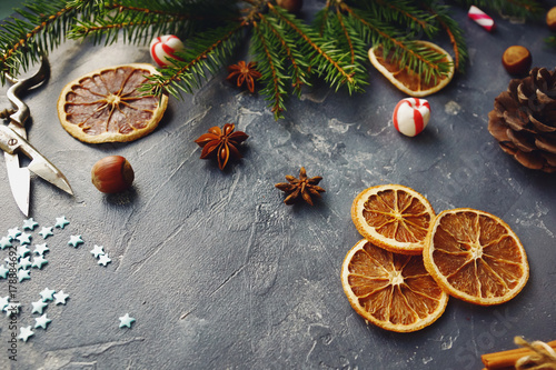 Cozy christmas background with dried oranges, fir tree, warm mittens, cinnamon and cones