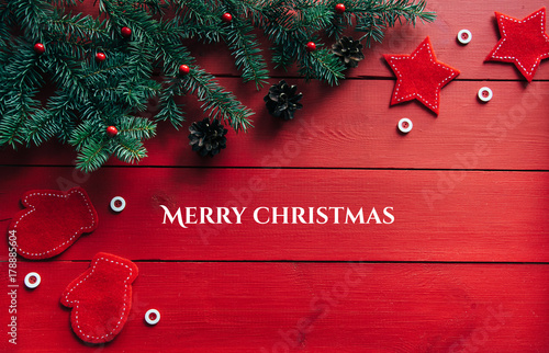 New year's background on a red desk decorated with toys, presents, Christmas tree, candles. Bright colored background symbolizes the new year celebration. Great useful template to wright words down. photo