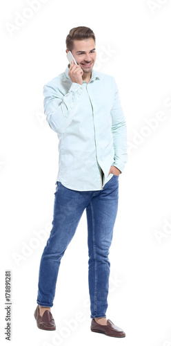 Young handsome man talking on his mobile phone against white background