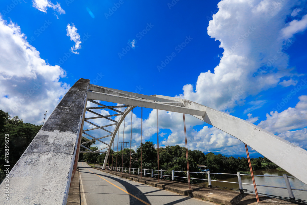 Old white bridge, bright sky and river in Thailand, beautiful background 