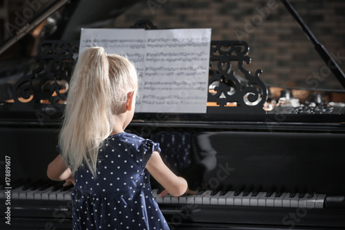 Little girl playing piano a...