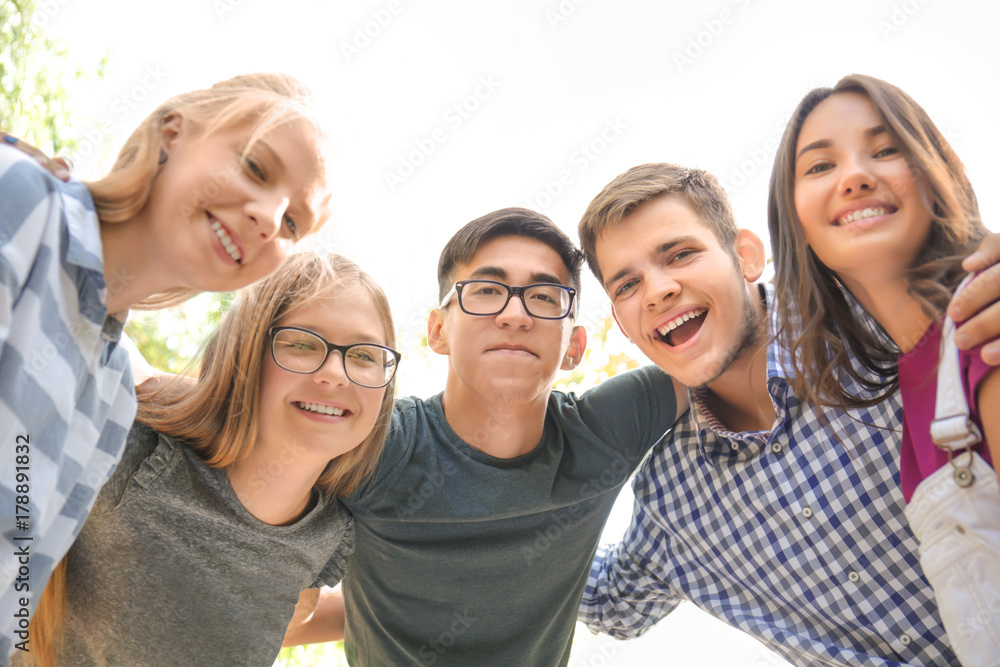 Happy teenagers hugging outdoors Happy teenagers hugging outdoors