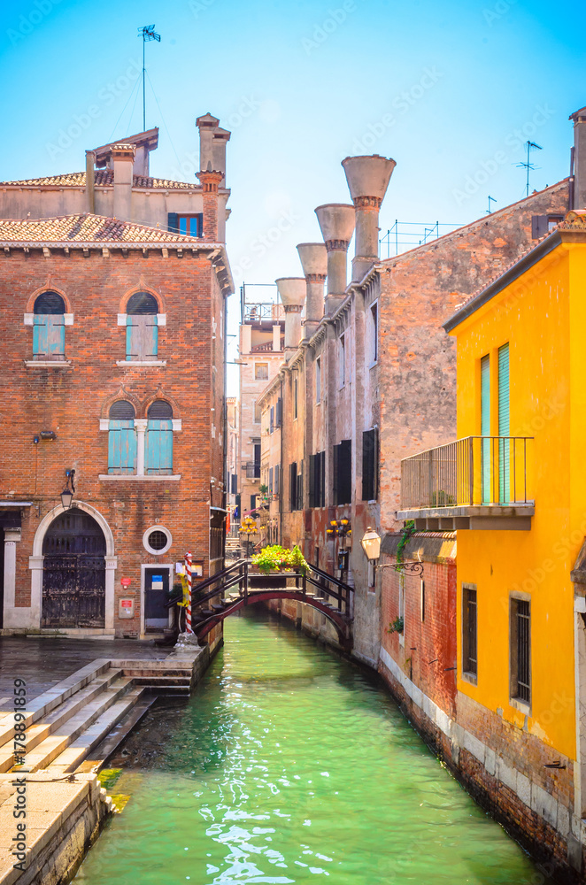 Traditional narrow canal with gondolas in Venice, Italy
