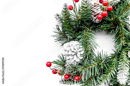 Christmas wreath woven of spruce branches with red berries on white background top view copyspace