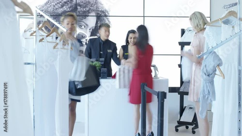 Time lapse staff serving customers in trendy clothing store. photo