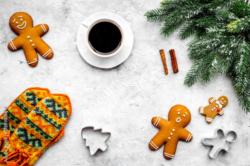 Cozy christmas evening. Coffee, cookies, spruce branch, knitten mittens on dark wooden background top view copyspace
