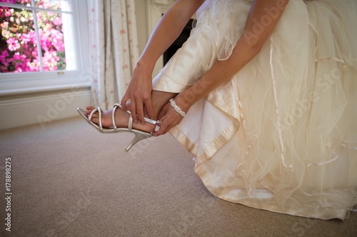 Low section of bride in wedding dress wearing sandals