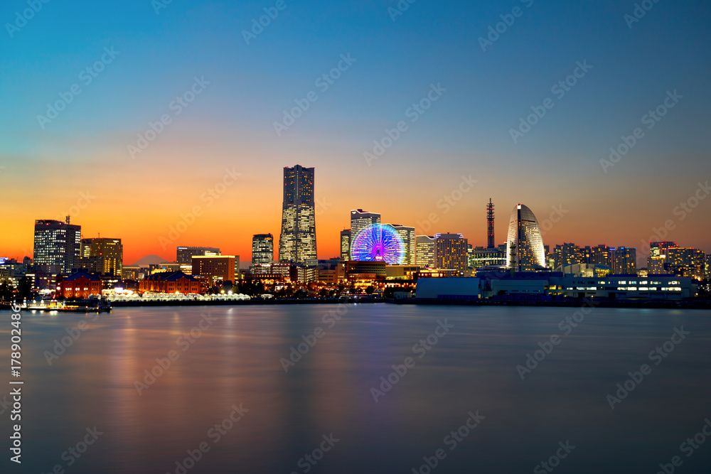 The city skyline at sunset of Yokohama, Japan with all the buildings illuminated and Cosmo Clock 21 spinning