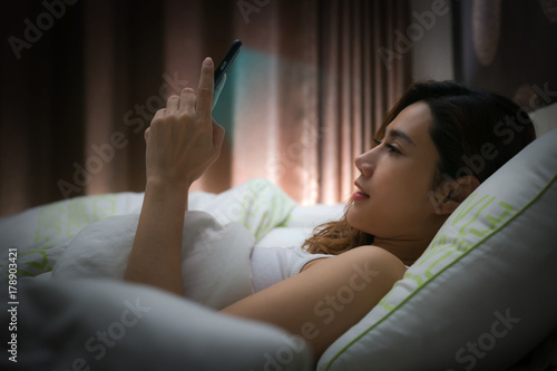 Woman with using modern devices on screen before sleep.