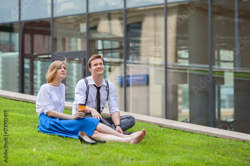 Young couple on green grass in city park © anrymos