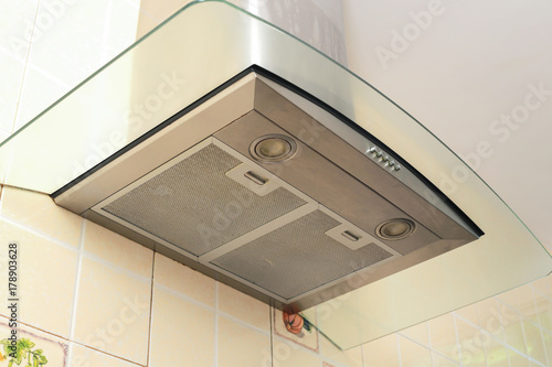 Принти на полотні Metal cooker hood extractor fan with spotlight in luxury kitchen.