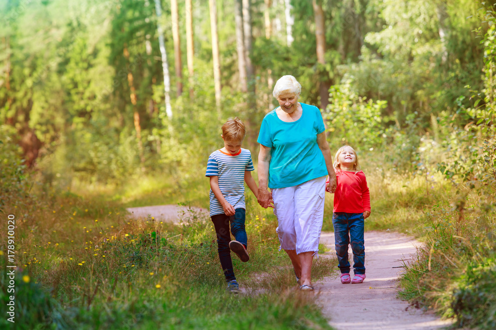 happy senior grandmother with kids walk in nature