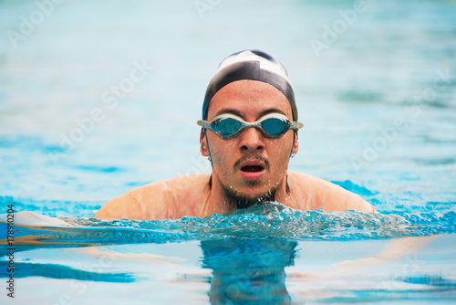 Man in goggles swimming in pool