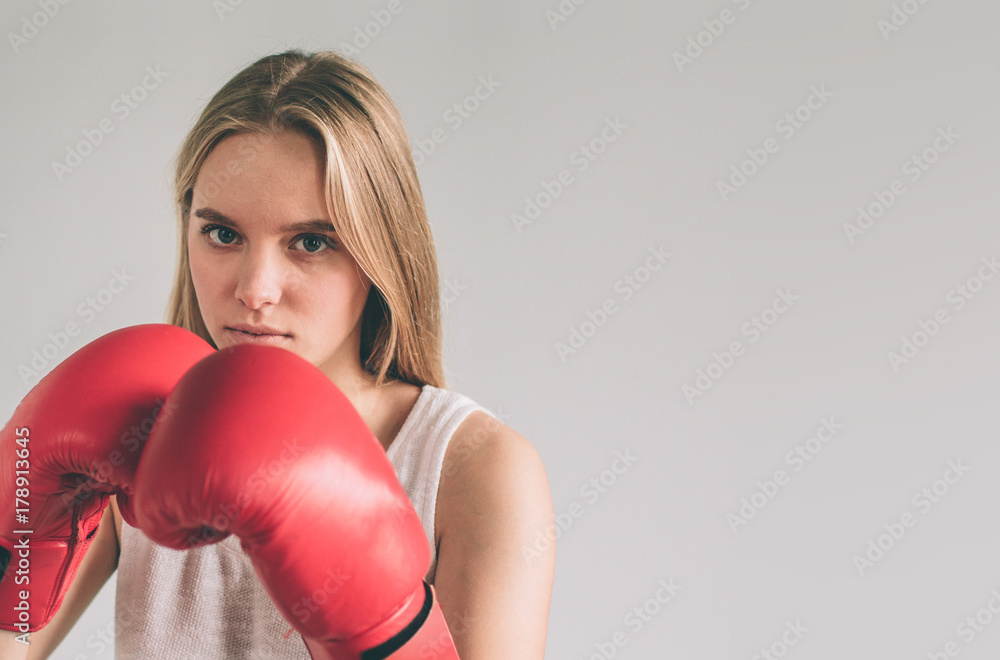Cowardly funny young woman in red boxing gloves. Blond girl is wearing glasses. Cowardly funny young woman in red boxing gloves. Blond girl is wearing glasses.