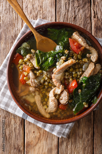 Philippine mung beans soup with pork closeup in a bowl. Vertical top view photo