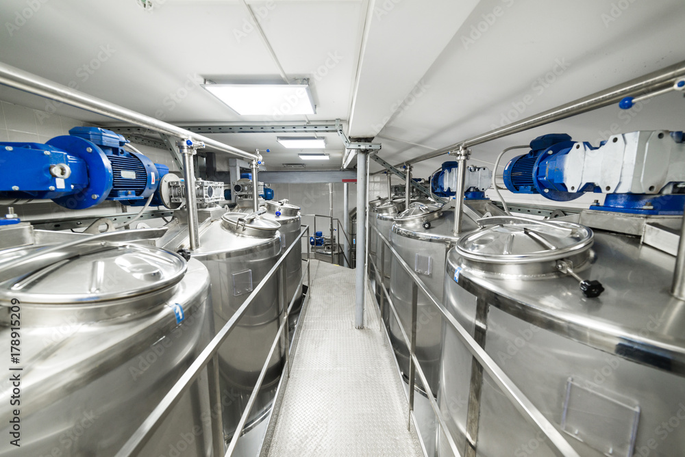 Obraz premium A long gangway between two rows of cisterns. Storage of food liquids.