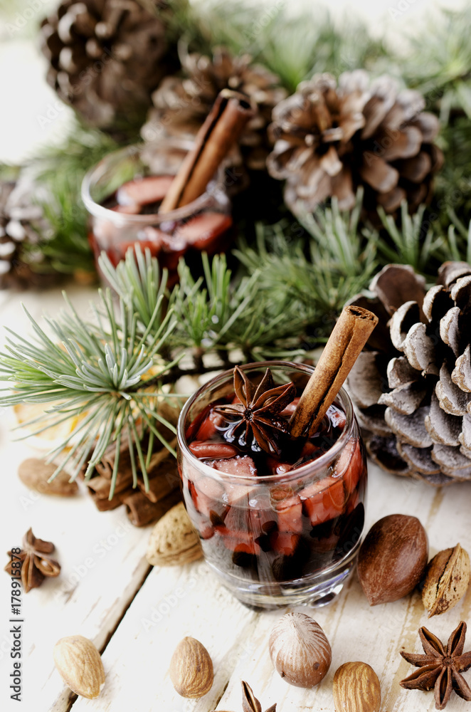 glass of hot mulled wine for the new year with ingredients for cooking, nuts and Christmas decorations glass of hot mulled wine for the new year with ingredients for cooking, nuts and Christmas decorations