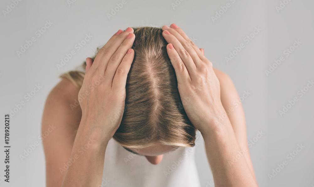 Women's hair is a top view close-up. Blonde woman is wearing shirt isolated on white. - obrazy, fototapety, plakaty 