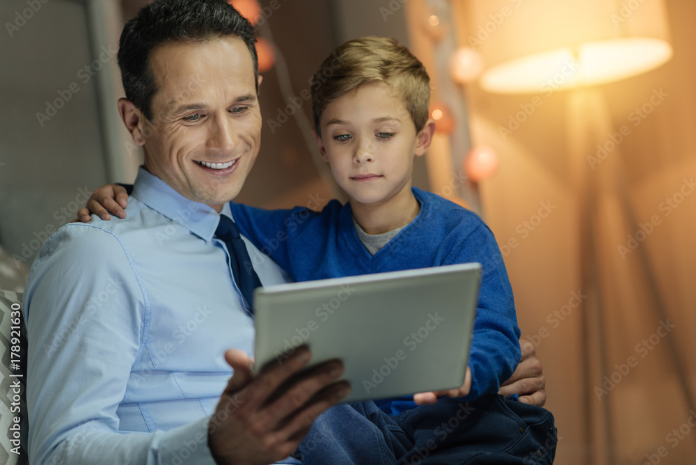 Positive delighted male showing his tablet Positive delighted male showing his tablet
