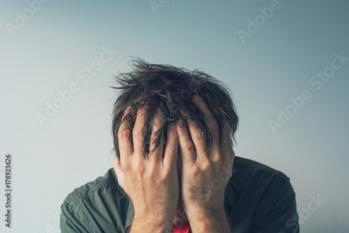 Disappointed man crying with head in hands