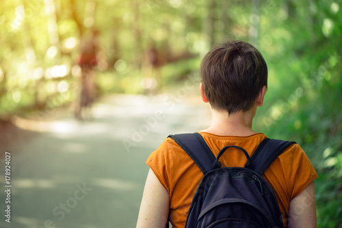 Woman with backpack enjoying walk in the park