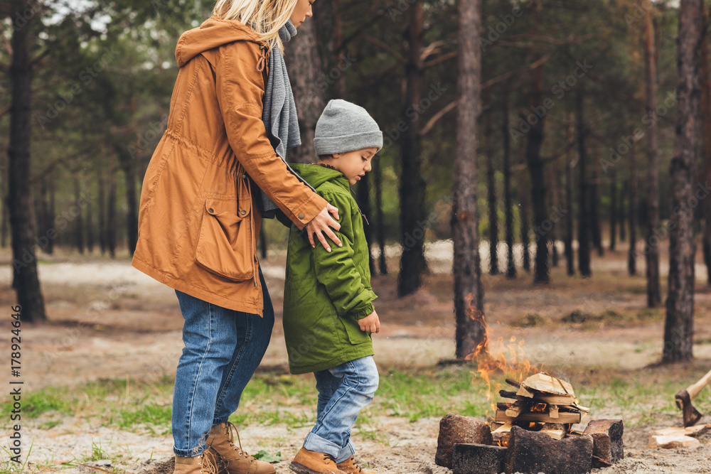 mother and son looking at campfire mother and son looking at campfire