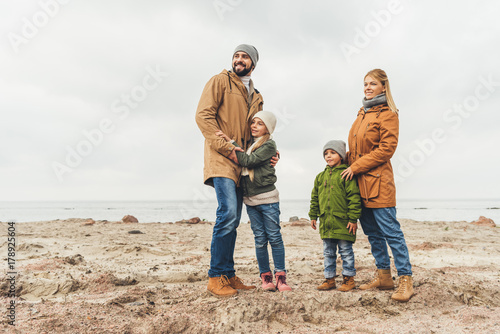 family embracing on sandy beach