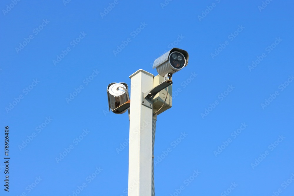 Two security cameras against blue sky background. Two security cameras against blue sky background.