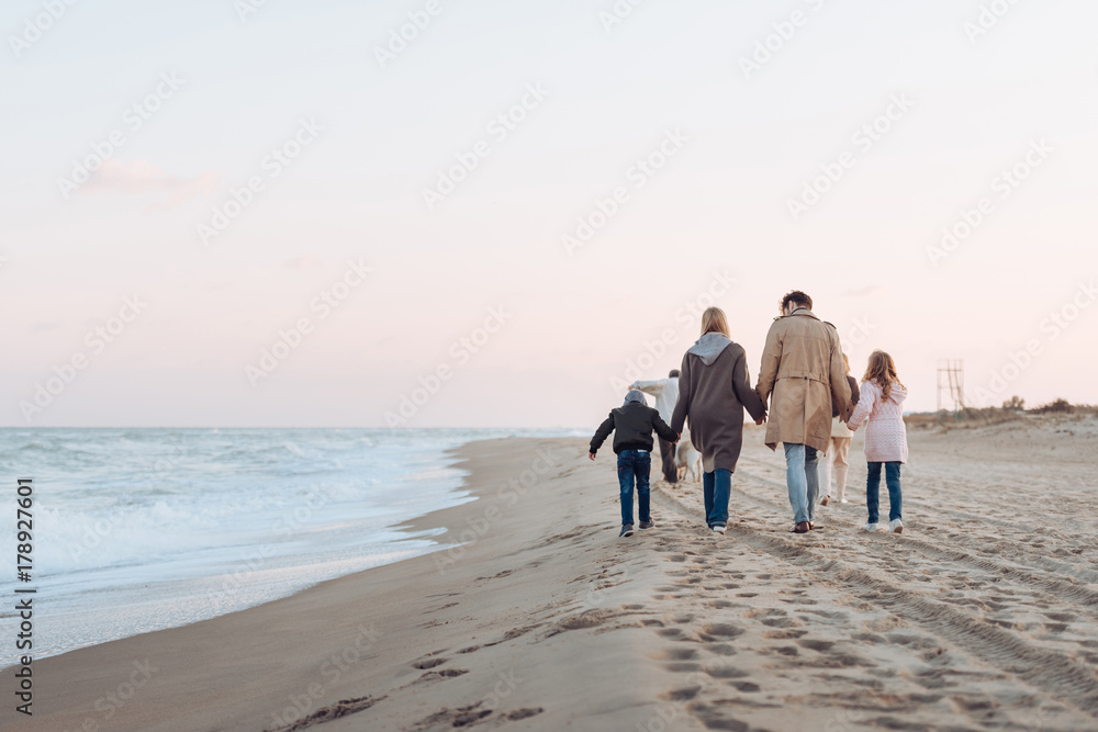 family walking on sandy beach