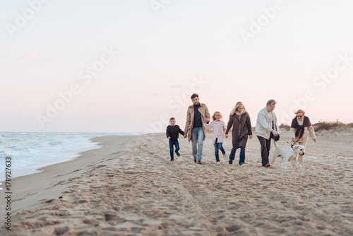 family walking with dog at seaside