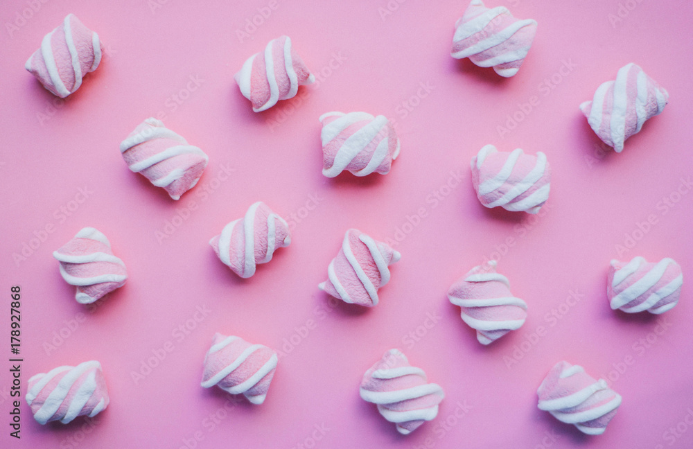 Marshmallows on pink background . Flat lay or top view. Background or texture of colorful mini marshmallows. Winter food background concept.