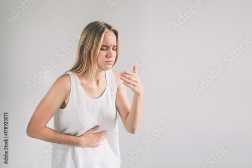 Young casual woman is having stomach ache.