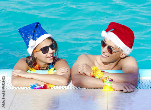 Romantic couple hugging in swimming pool, enjoying in tropical Christmas vacations © kravik93