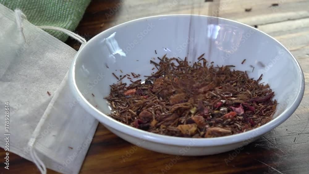 Pouring rooibos tea with strawberry and kiwi into a sample dish Pouring rooibos tea with strawberry and kiwi into a sample dish