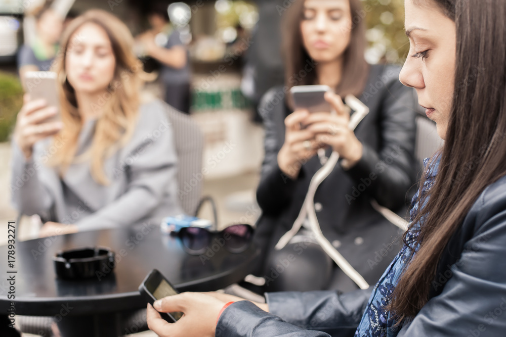 Three woman in cafe using app smartphone playing social network Three woman in cafe using app smartphone playing social network