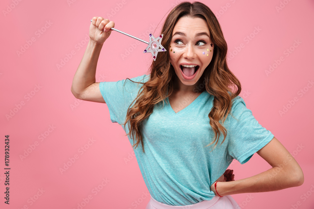Smiling emotional young woman holding magically stick star Smiling emotional young woman holding magically stick star