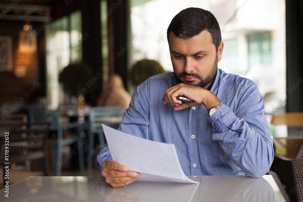 Worried man looking at paper Worried man looking at paper