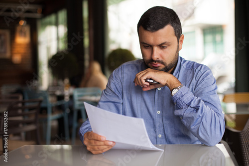 Worried man looking at paper