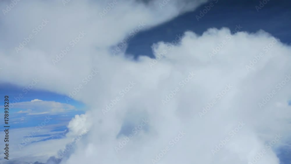 Above the clouds, flying in the air, Clouds against blue sky view through an airplane window for a background.video 4k Above the clouds, flying in the air, Clouds against blue sky view through an airplane window for a background.video 4k