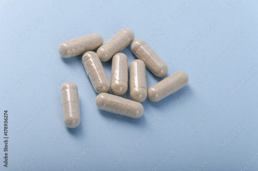 transparent medical capsule isolated over a light brown background. transparent medical capsule isolated over a light brown background.