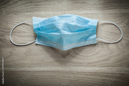 Disposable surgical sterile mask on wooden board