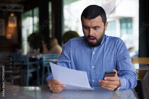 Surprised man looking at paper