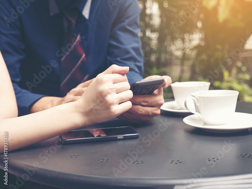 Couple of lover  people  communication and technology concept - close up of couple with smartphones drinking tea at cafe or restaurant