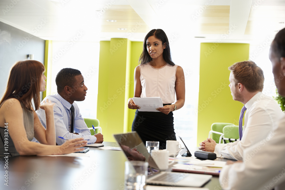 Female boss stands holding document at informal work meeting Female boss stands holding document at informal work meeting