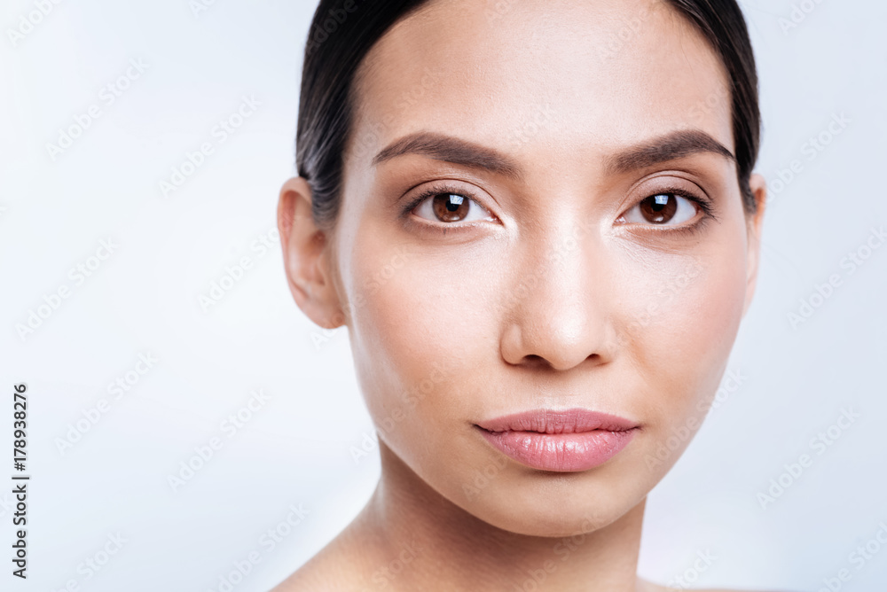 Close up of dark-haired dark-eyed woman with full lips Close up of dark-haired dark-eyed woman with full lips