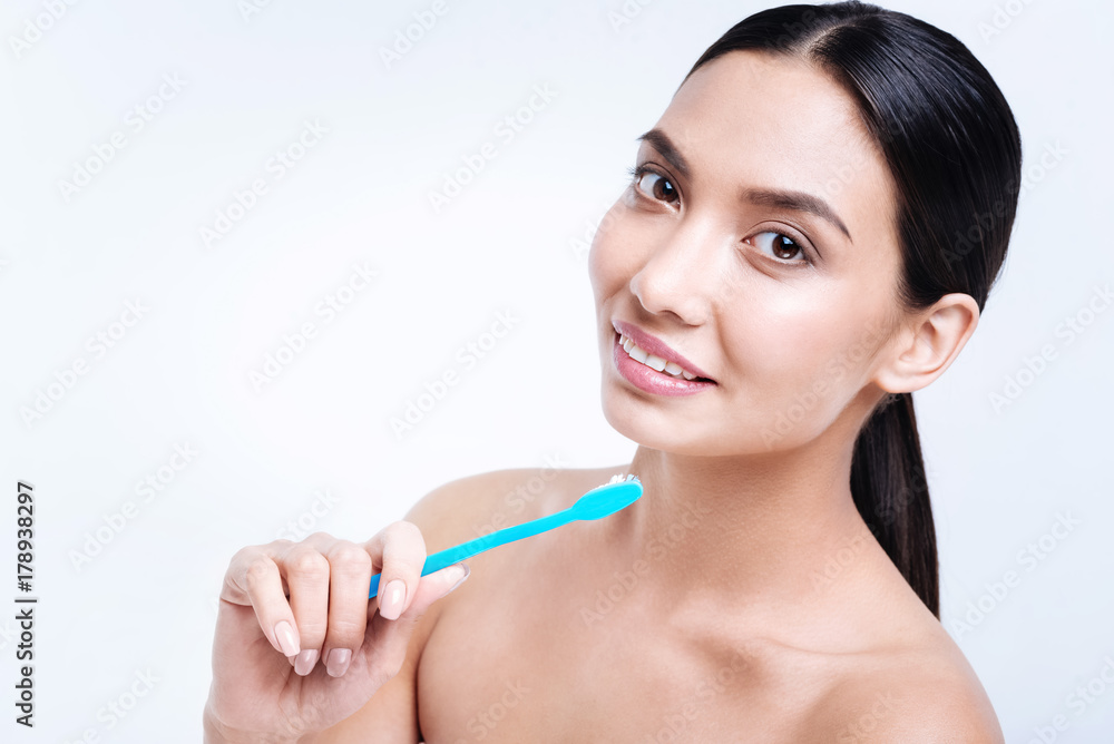 Pleasant young woman posing with a green toothbrush Pleasant young woman posing with a green toothbrush