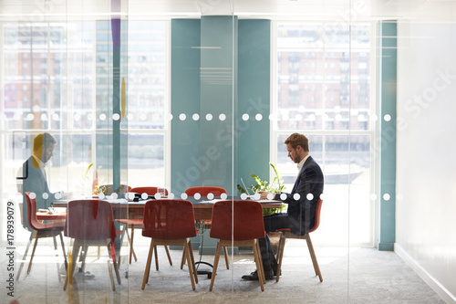 Young businessman working alone in an office meeting room